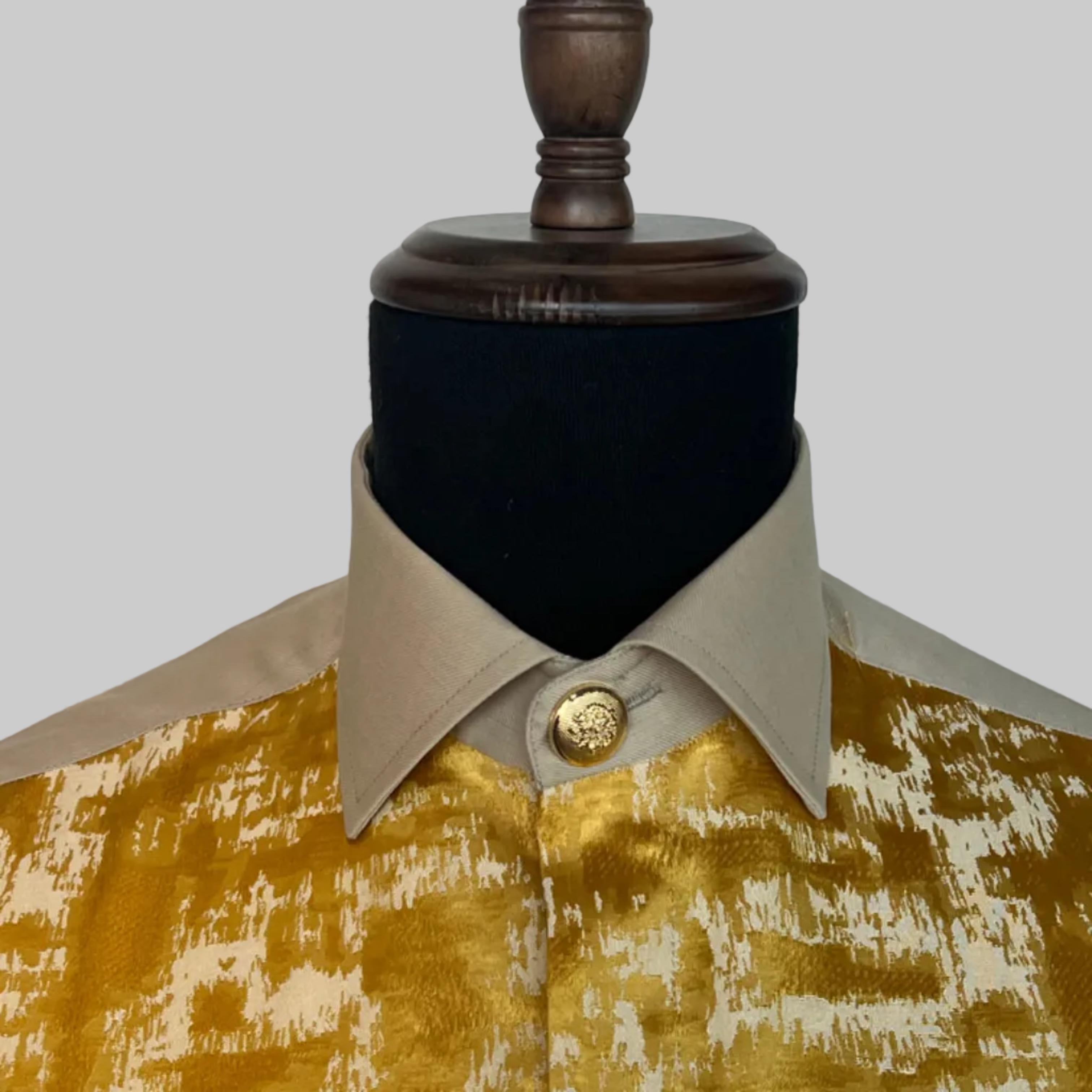 Man wearing a beige shirt with a gold and beige patterned design.