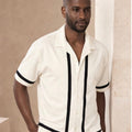 Man wearing a white shirt with black trim 